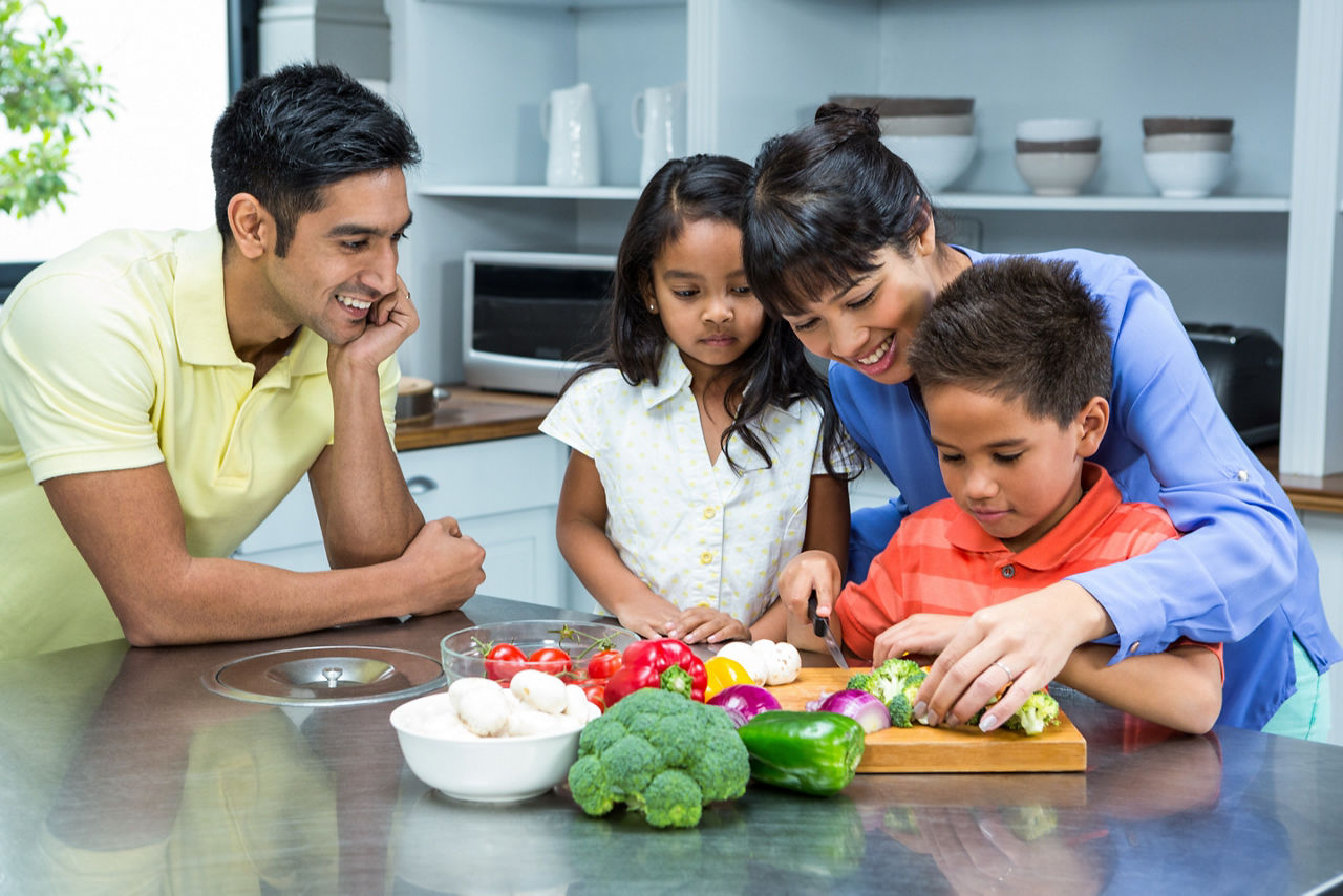 Family gathered around counter with veggies